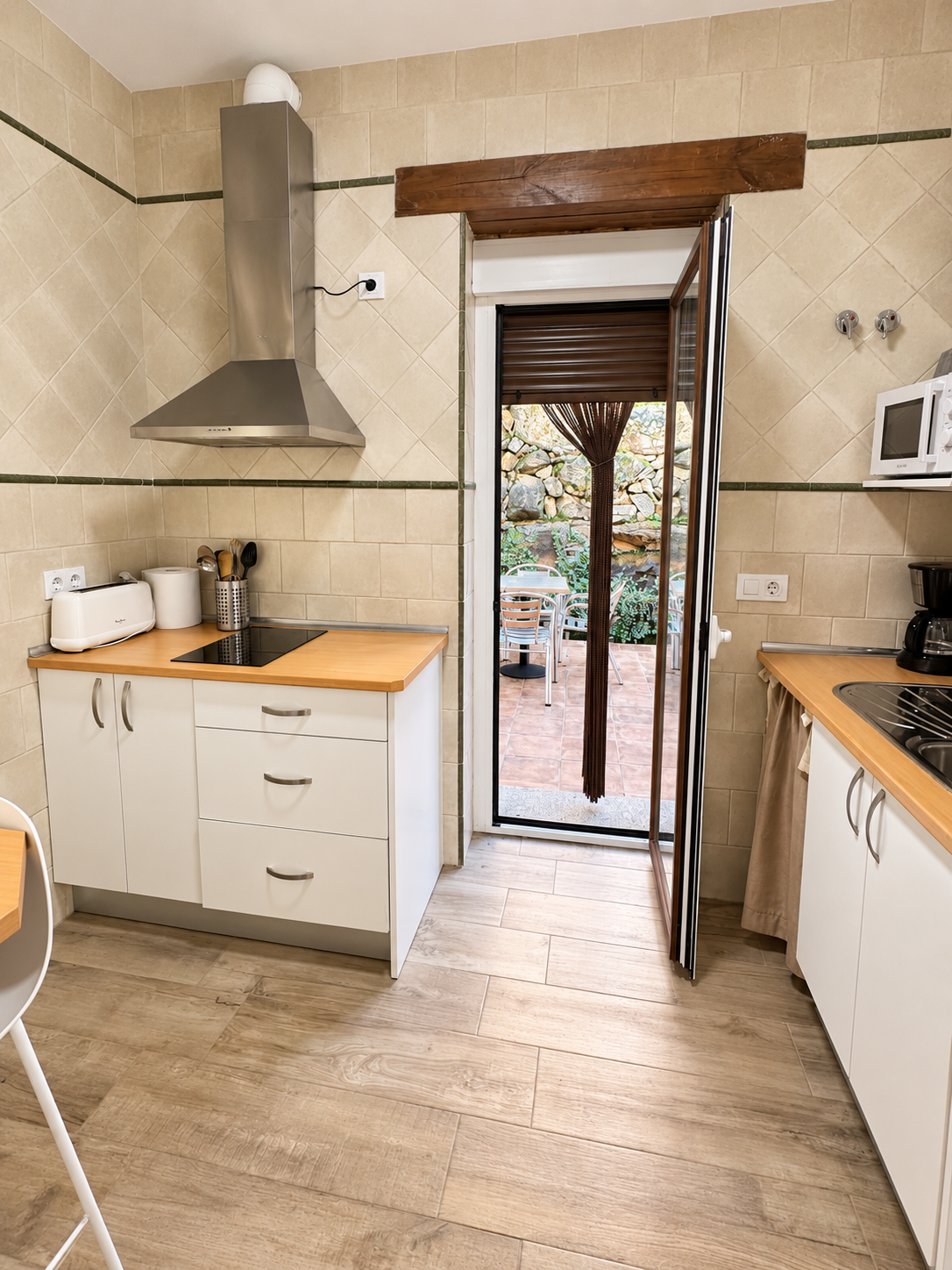Equipped kitchen of Lavanda Apartment opening onto the patio