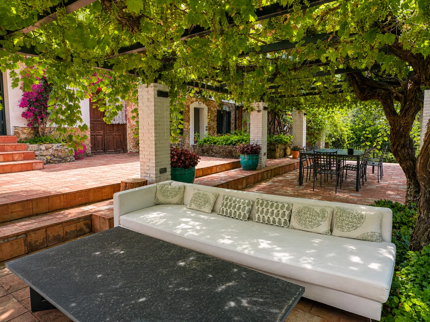Porch of Villa Alardos with a sofa and the table under the vine