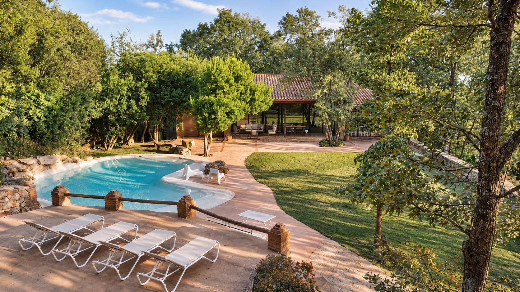 Pool at Villa El Bosque surrounded by lawn and trees