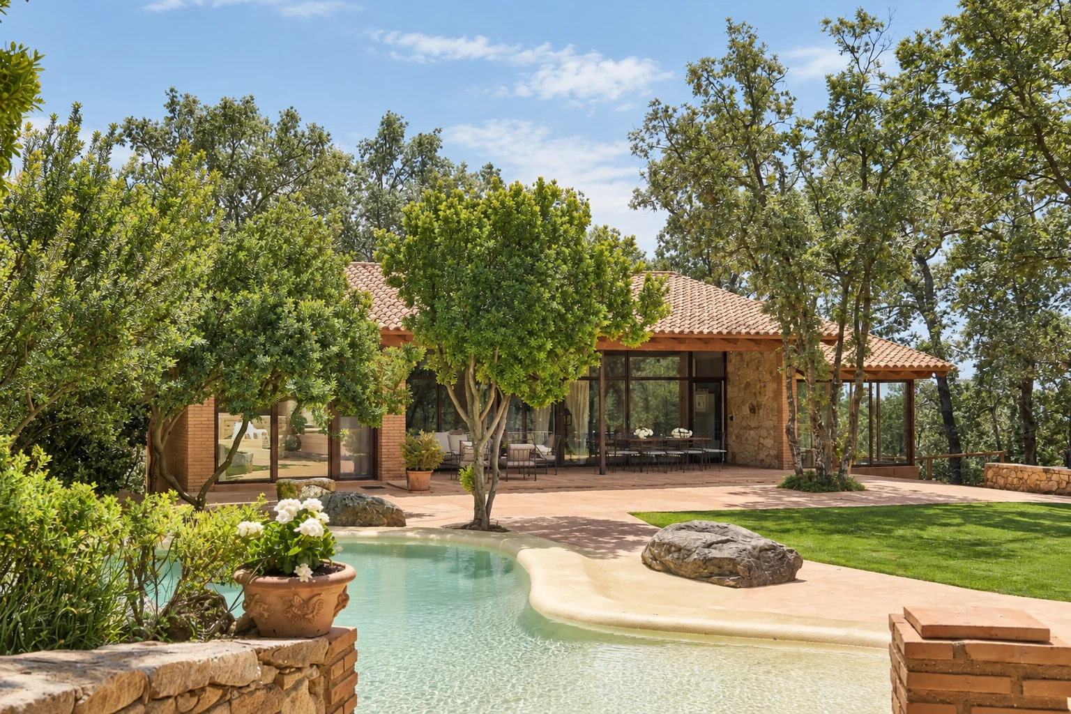 Pool, garden and facade of Villa El Bosque among holm oaks