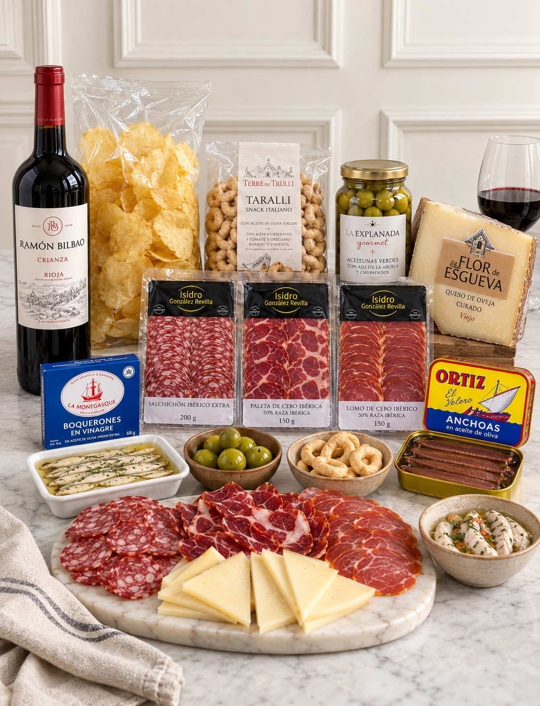 Contenido del Pack Aperitivo Gourmet: vino Rioja, embutidos ibéricos, queso de oveja, aceitunas, anchoas, boquerones, patatas fritas y taralli