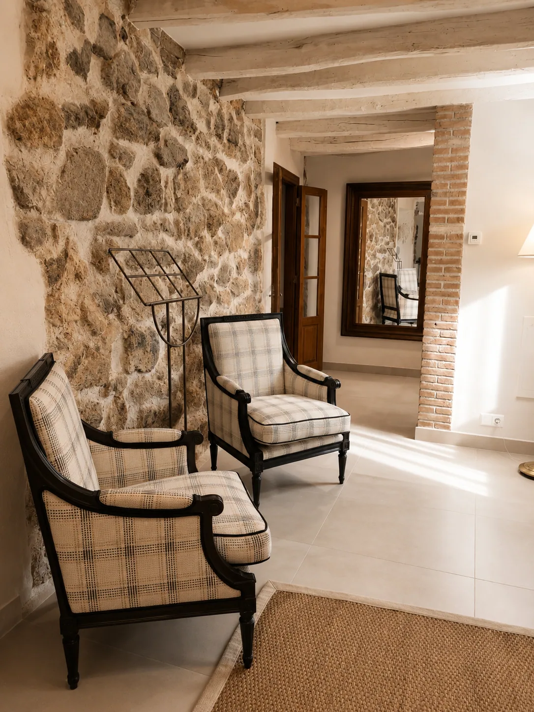 Entrance hall of Villa Alardos with a stone wall and armchairs