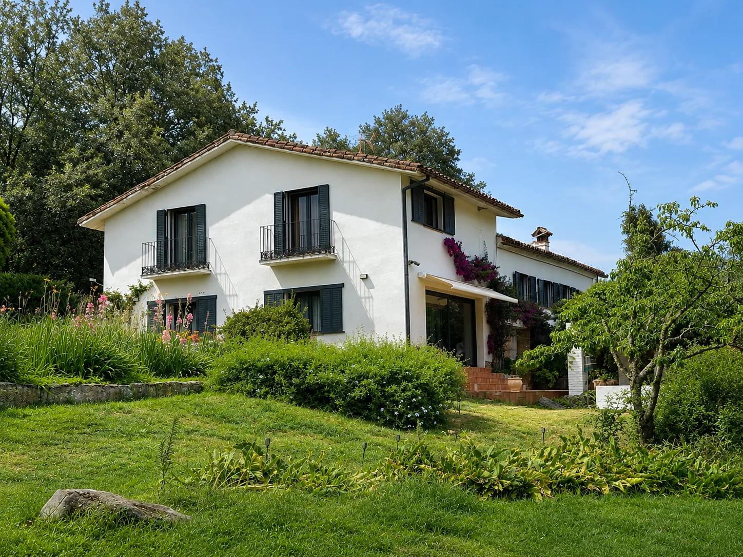 Villa Alardos with its shutters and the sloping garden