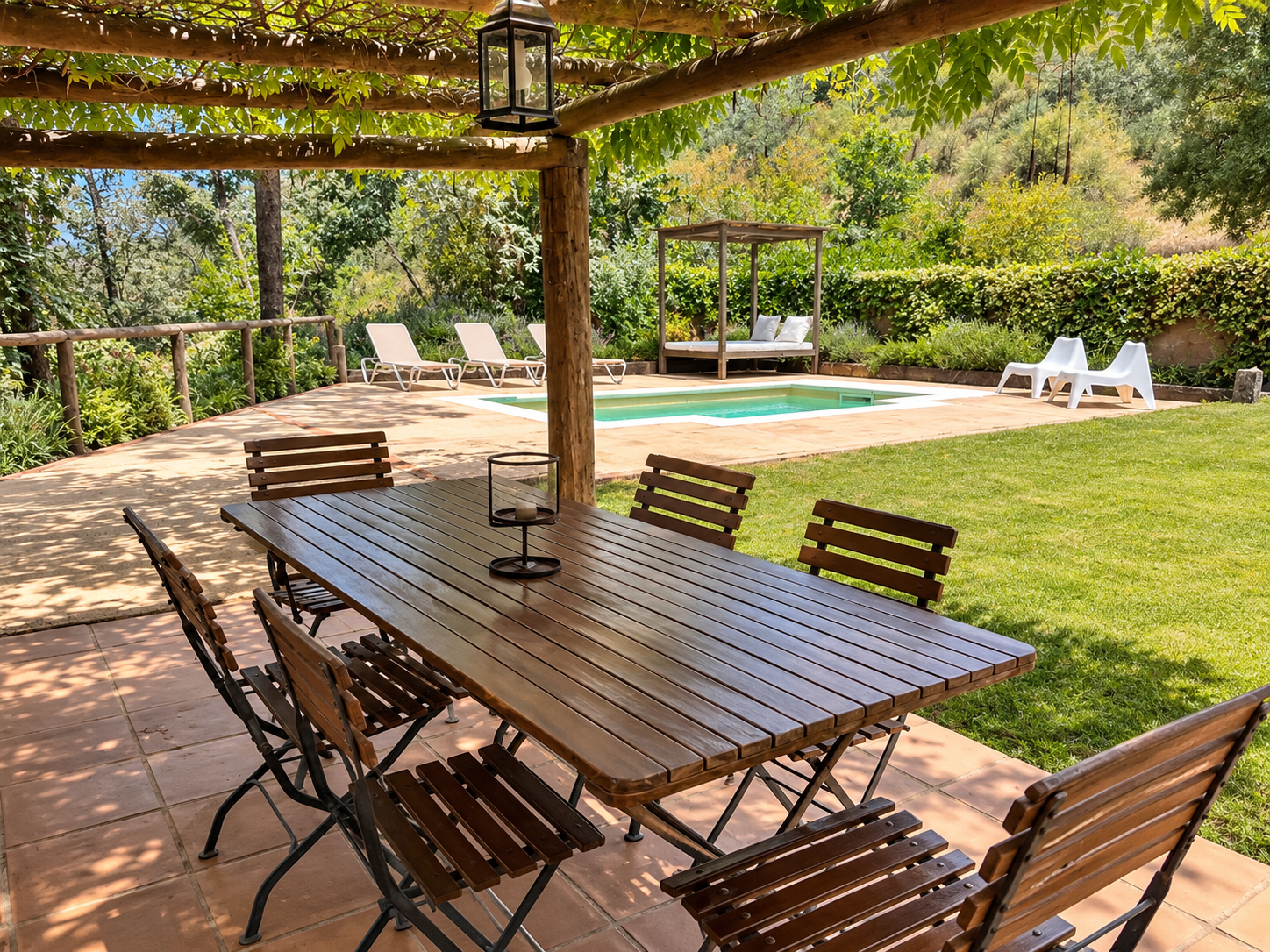 Outdoor dining area beside the pool at Villa Los Fresnos