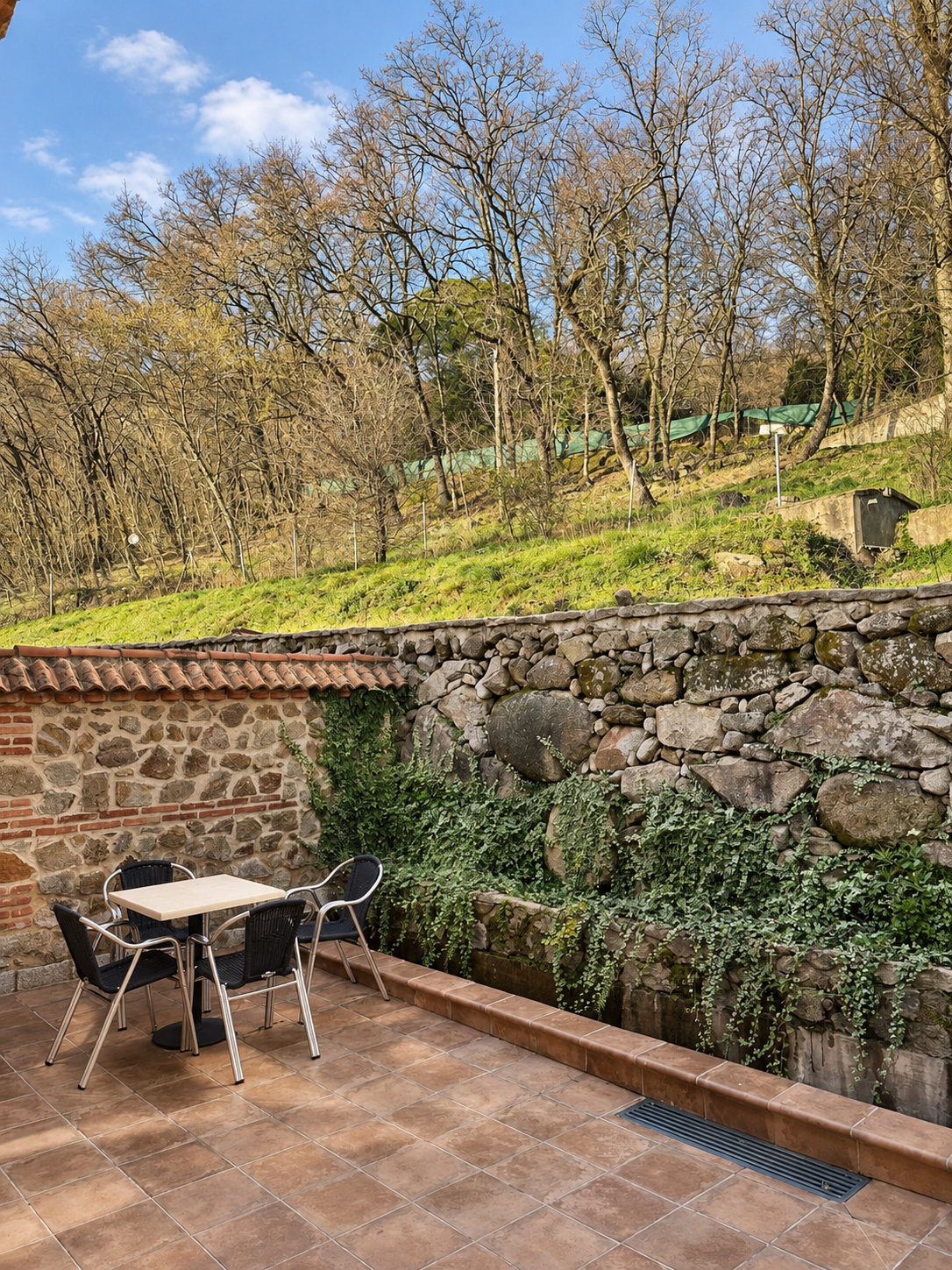 Private patio of Romero Apartment beside the stone wall