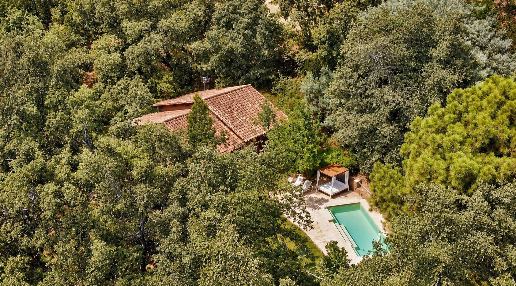 Aerial view of a villa with pool surrounded by holm oaks on the El Escondite estate, Candeleda