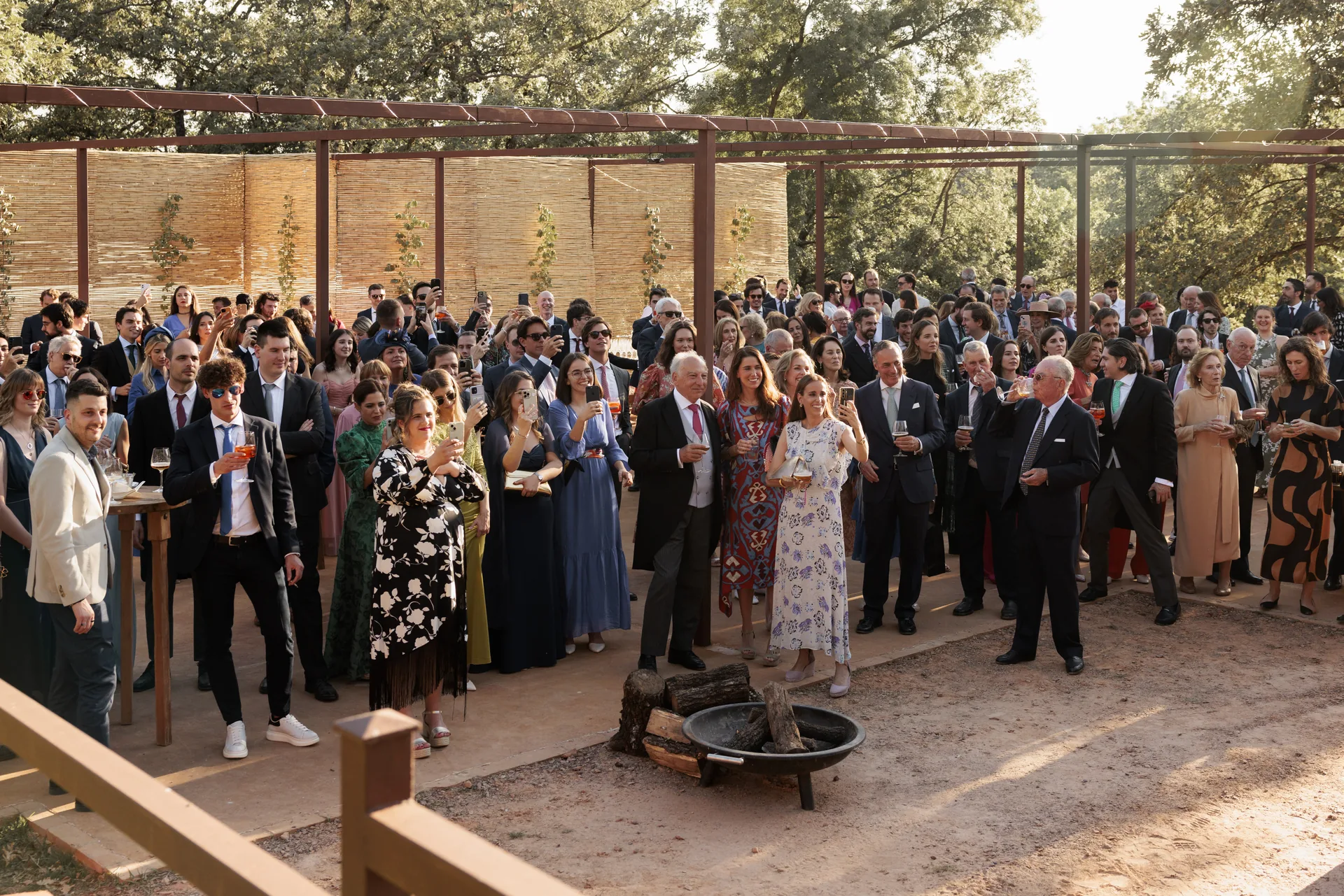 Guests celebrating together during the aperitif under the holm oaks