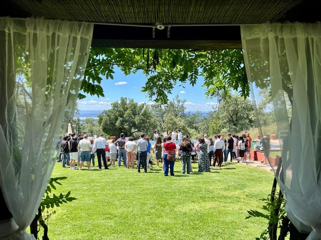 Group gathered on the estate's lawn, seen from a porch